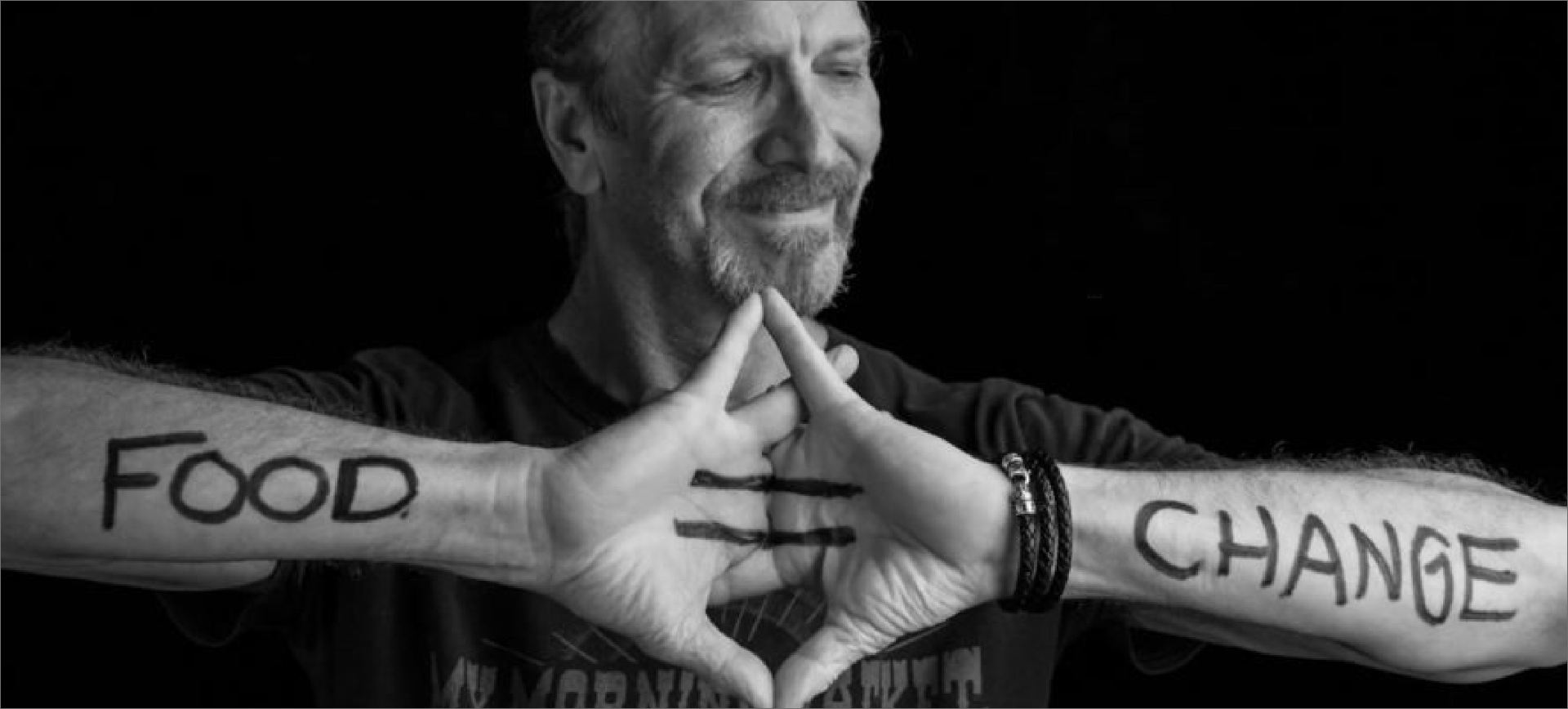 A man with "Food = Change" written on his arms